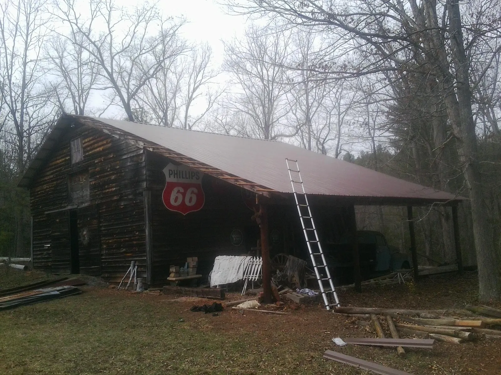 New metal roof on an open sided timber barn with a vintage sign in Bairdford