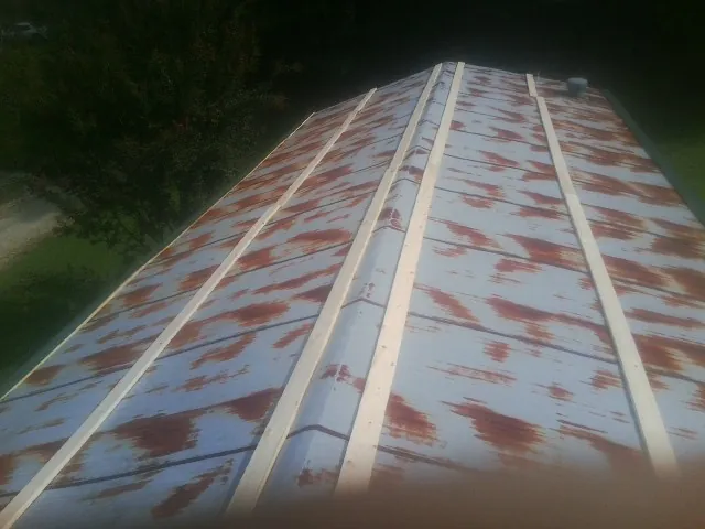 Rusted metal roof panels with new wood purlins before replacement — Storm Damage Roof Repair in Bairdford by Roofing Brothers
