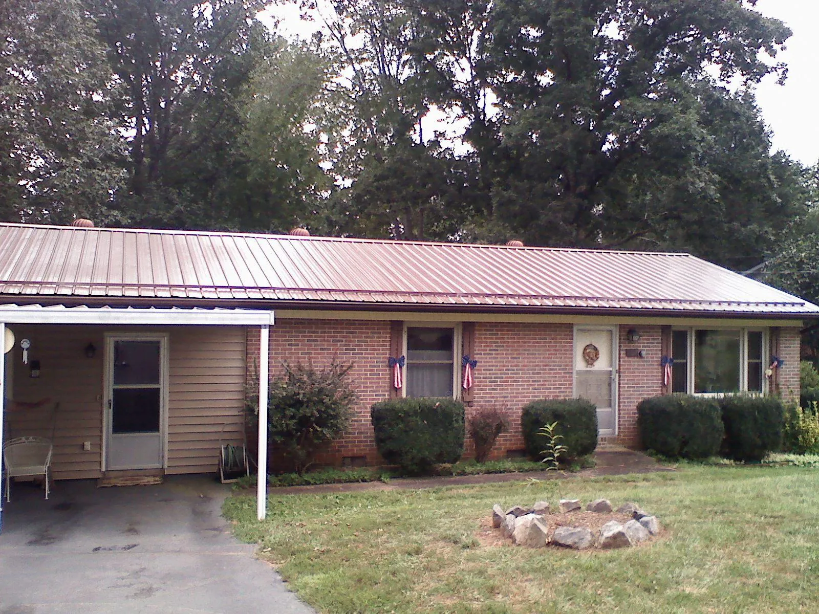 Bronze metal roof and carport on a brick ranch home — Roof Repair work by our crew in Bairdford